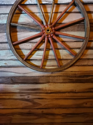 Wagon wheel on wood clad wall with copy space