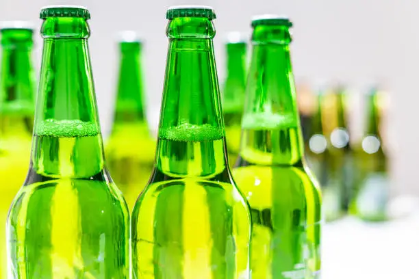 Group of a lot of green bottle beers with a blurry background. Bottle beers on the background.