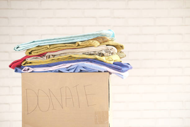 istock Donation box with donation clothes on a wooden table . 1312826099