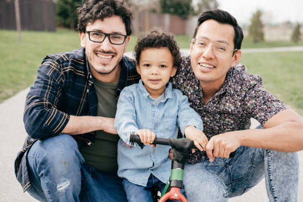glückliche familie mit zwei vätern und kleinkind sohn - homosexual stock-fotos und bilder