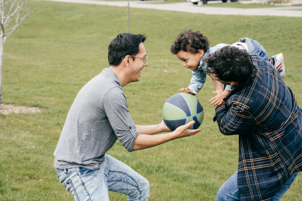 istock Playing basketball -  two dads and toddler son 1312829378