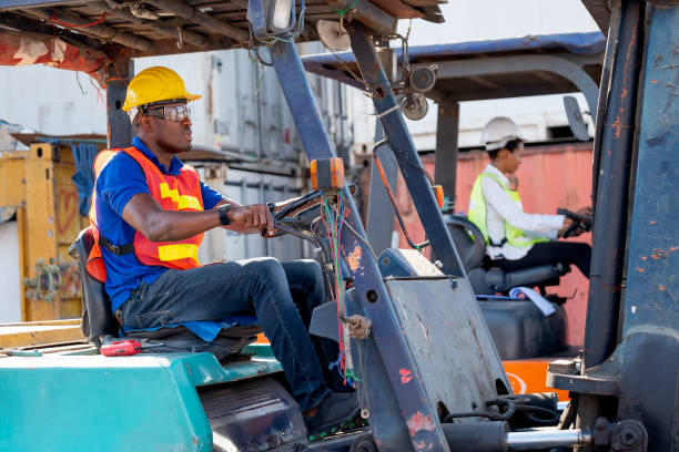 istock African American foreman or cargo container worker drive cargo car beside of his co-worker woman in workplace area 1312830708