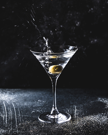 Martini with olives making a splash