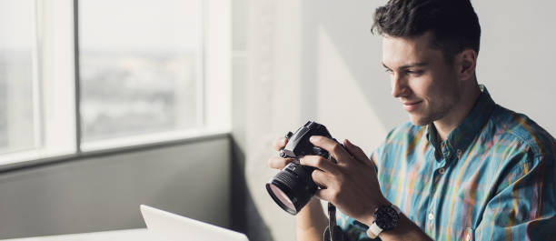 istock Photographer looking at photo camera at home. Banner 1312831721