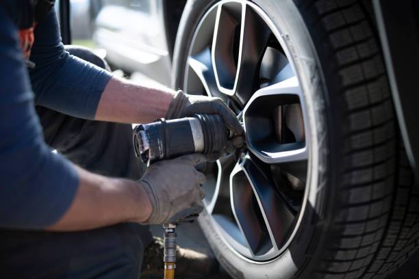 changement de pneus dans un service de voiture - pneus photos et images de collection