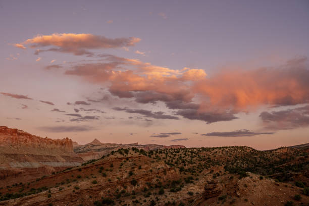 istock Pink Clouds Pass Over Capitol Reef Horizon At Sunset 1312834782
