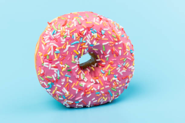 istock Fresh made Donuts isolated on blue background. Doughnuts are traditional sweet pastries. Copy space for text. 1312838232