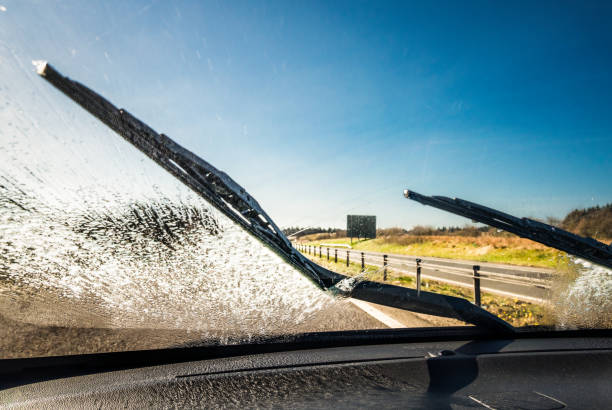 löschen der windschutzscheibe während der fahrt - washing water car cleaning stock-fotos und bilder