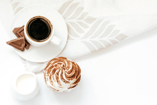 istock Dark chocolate and cocoa chocolate cupcakes with a cup of hot black coffee. Space for text 1312839644