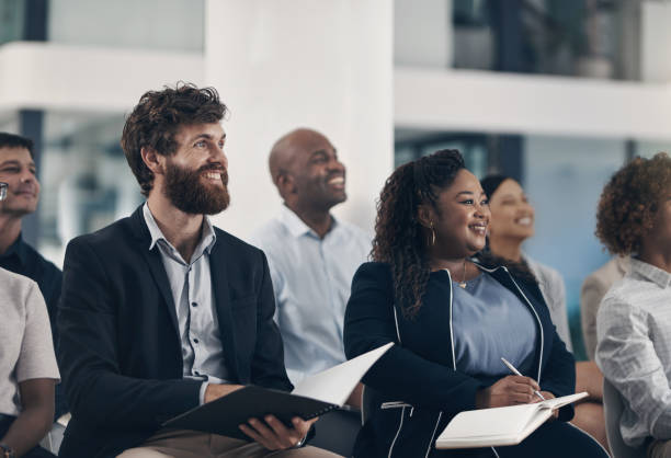 istock Shot of businesspeople taking notes while attending a presentation 1312840099