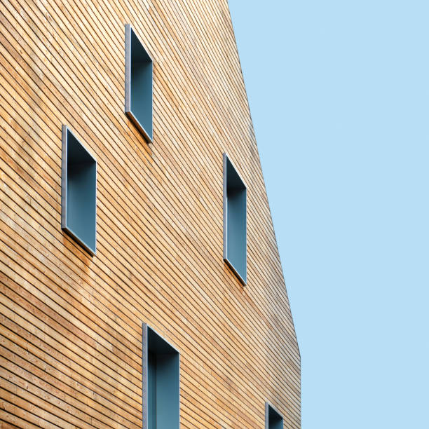 Wooden wall of modern building with windows against blue sky