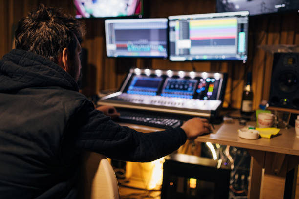 ingénieur du son masculin dévoué, travaillant sur des trackouts ondulants, dans son studio d’enregistrement de musique - studio de post production photos et images de collection