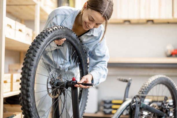 ワークショップで自転車を修復する便利な女性 - reparing ストックフォトと画像