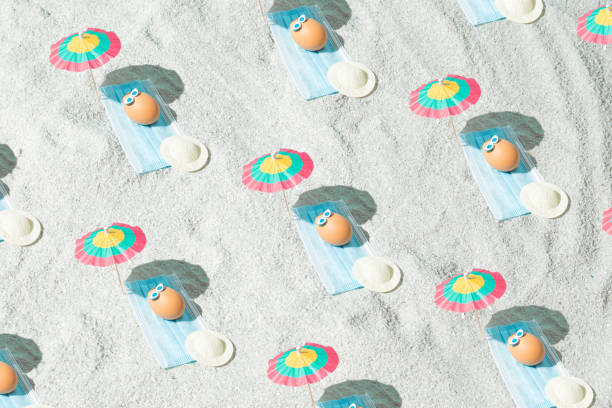 istock Summer Easter pattern background with eggs, virus mask, beach umbrella and glasses. Minimal pandemic or holiday concept. Safe distance. Top view. 1312849882