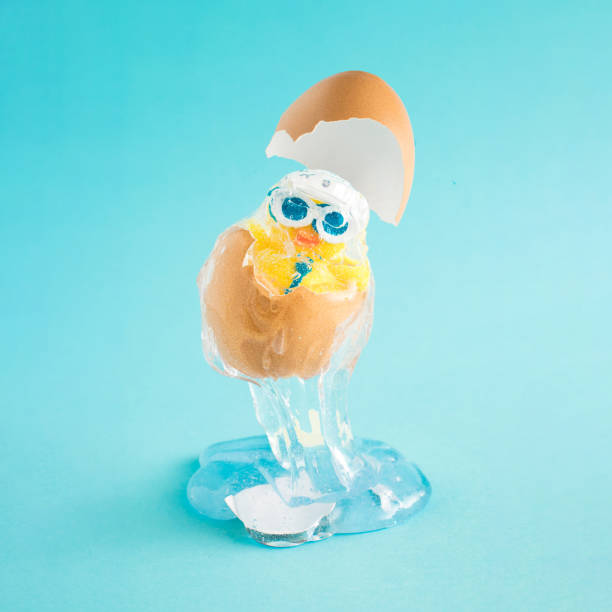 istock The Creative Easter composition with a party chicken with a hat and glasses in a cracked natural egg levitates above the blue background. Creative party or holiday concept. 1312850001