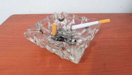 cigarette ashtray in open area, many butts in cigarette ashtray,