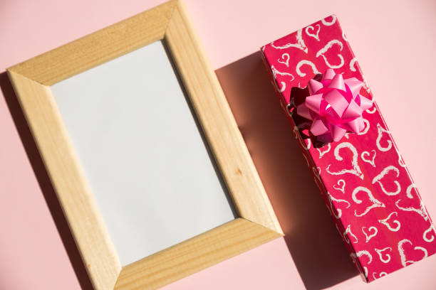 istock Happy Valentines Day with empty wooden photo frame, present box, gift on pink background. Valentine day, mother day, wedding anniversary concept. Top view with copy space.Minimal flat lay style 1312850872