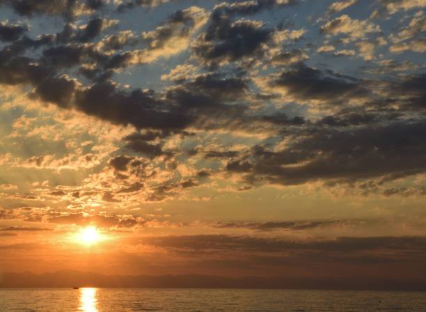 istock Rising sun in cirrus clouds on the sea coast 1312854907