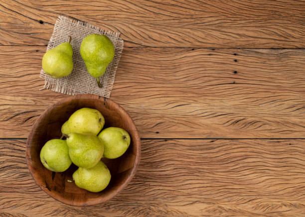 istock Green pears in a bowl over wooden table with copy space 1312854970