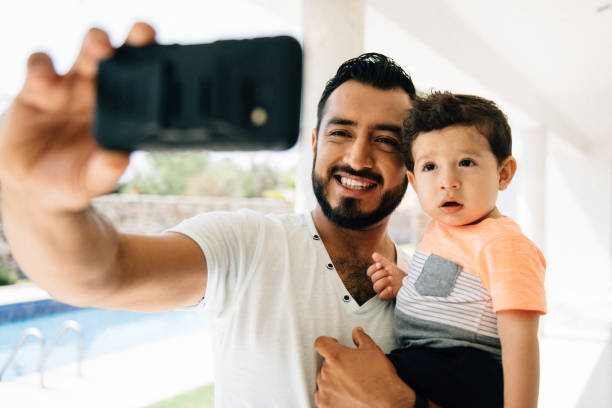 istock Father on video call holding toddler 1312855780
