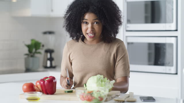 4k video footage of a young woman recording herself making a healthy meal at home