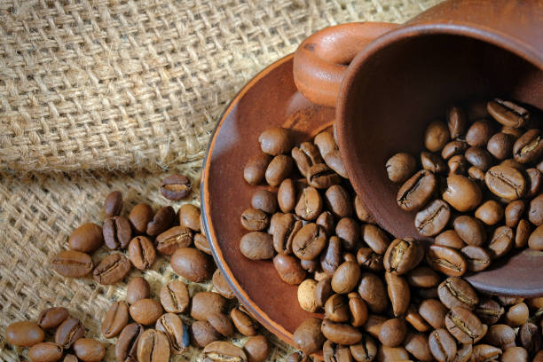 istock Coffee cup and roasted coffee beans on burlap. Coffee background close-up. 1312860928