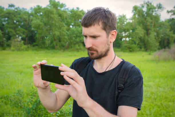 istock A young man outdoors watching a video on the phone. Lifestyle. 1312860968