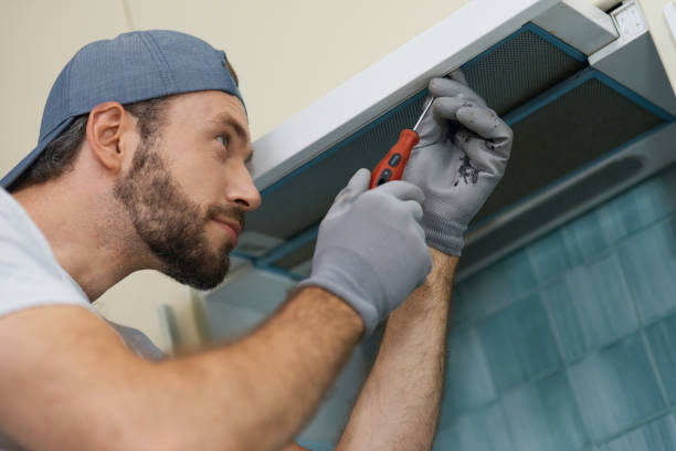 istock Dedicated to service. Portrait of young handyman looking focused while fixing a kitchen extractor with a screwdriver indoors 1312862996