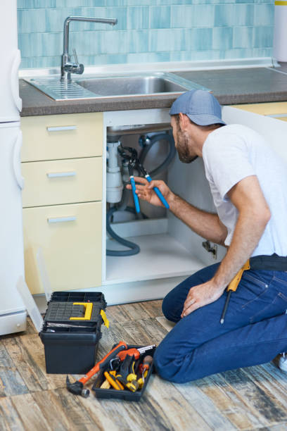 istock Plumbing troubles. Professional plumber using pipe wrench while examining and fixing sink pipe in the kitchen 1312863023