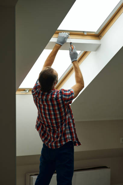 istock Helping you to fix it. Rear view of handyman using screwdriver while fixing or installing a window in a new dry wall attic 1312863037