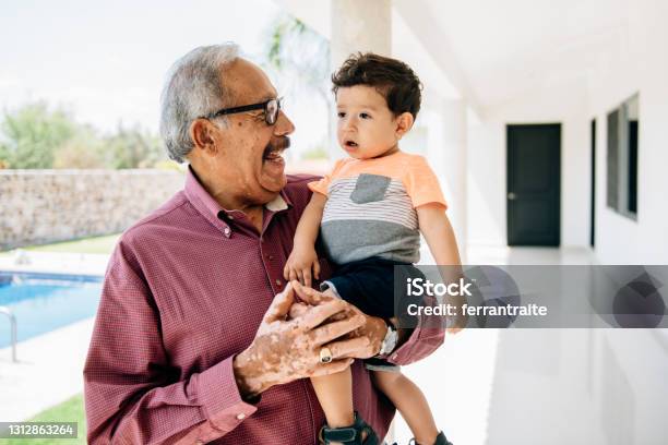 Grandfather Holding Grandson Toddler By The Swimming Pool Stock Photo - Download Image Now