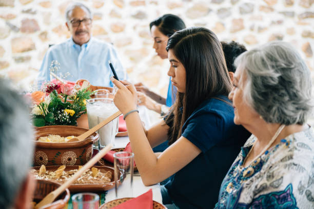 istock Teenage girl using smartphone during family dinner 1312865714