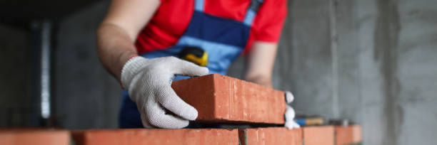 istock Builder makes a brick wall in a house close-up 1312869620