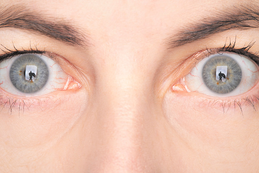 A macro photo of a woman's blue eyes.