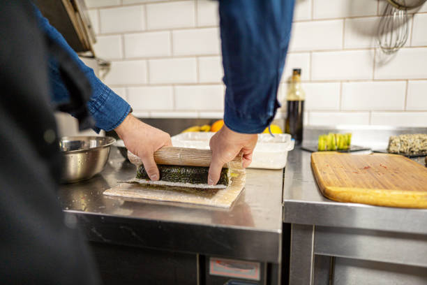 istock Young Man Preparing Sushi On Cutting Board 1312876482