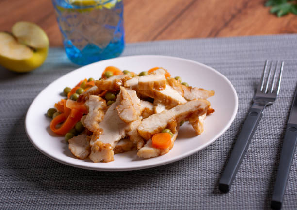 istock roasted chicken meat with pea and carrot garnish - closeup 1312876559