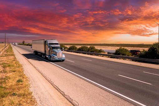 A long haul truck driving on I-5 in California's Central Valley