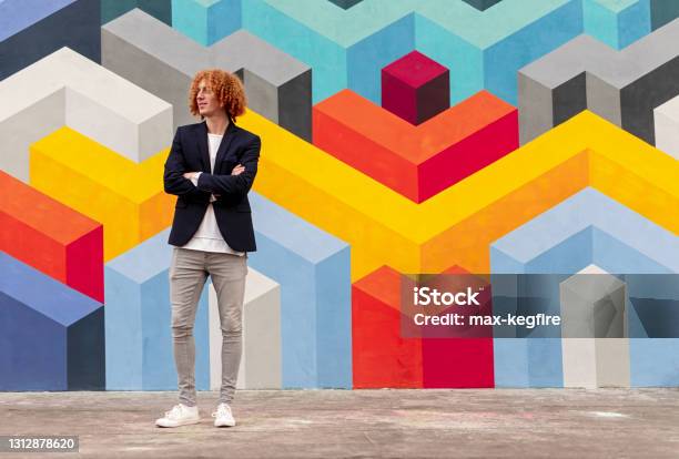 Self Assured Guy Standing Near Geometric Wall With Crossed Arms Stock Photo - Download Image Now