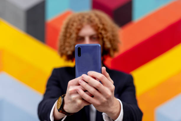 Anonymous man taking selfie against geometric graffiti wall