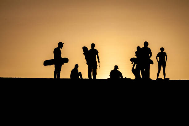 sylwetki snowboardzistów piasku podczas zachodu słońca w pobliżu pustynnej oazy huacachina w pobliżu ica, peru - ice zdjęcia i obrazy z banku zdjęć