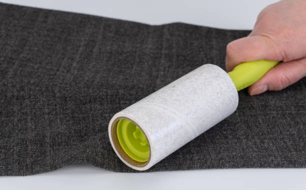 rouleau collant réutilisable pour nettoyer les vêtements. mise au point sélective. conçu pour enlever la poussière, la laine, peluche de n’importe quel type de tissu. nettoie la surface sans laisser de traces, tourne facilement. - lint remover photos et images de collection