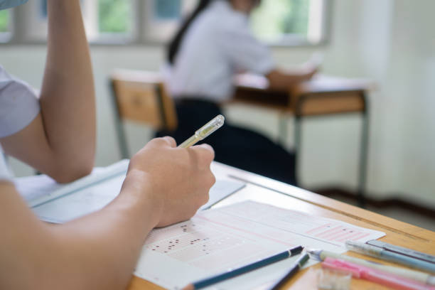 istock Hands Student testing in exam on exercise taking at high school or university in test room. Writing document exams at campus classroom, back to school and evaluation measurement in education 1312895321