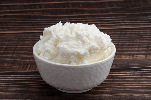 Freshly Churned White Butter Also Known As Safed Makhan Malai Or Homemade Makkhan In India Is Used To Prepare Desi Ghee In White Bowl. Isolated On Brown Wooden Background With Copy Space For Text