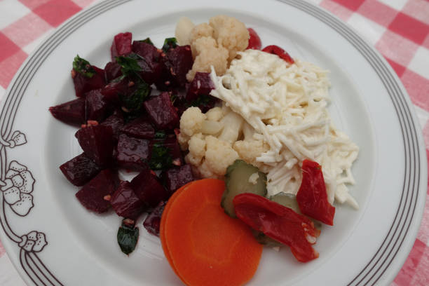 Appetizers served on a plate  Beetroot celery root cauliflower in brine carrot  Portioned food  Self-service meal buffet