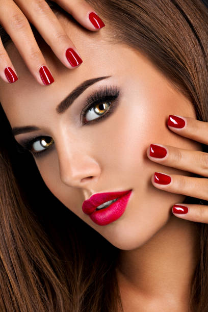 istock seductive woman with dark brown eye makeup and bright red lips and nails 1312912284