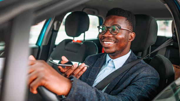 istock Young Man With Smartphone Driving Car. 1312913164