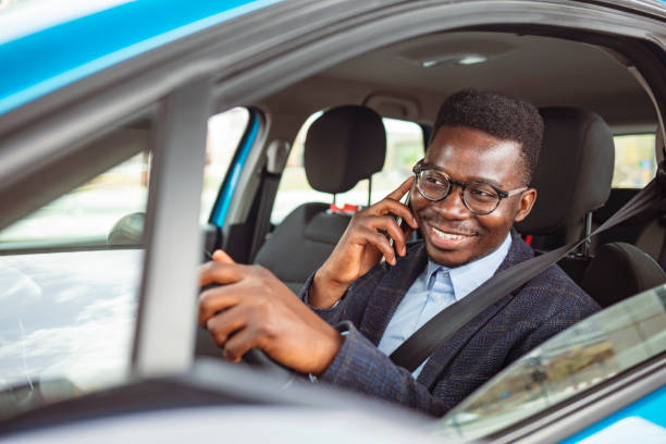 istock Handsome Businessman Talking on the Phone while Driving a Car to Work. 1312914008