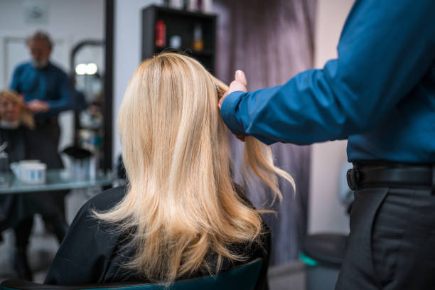 istock Female Blonde In 40's Having Her Hair Checked Before Cutting 1312914818