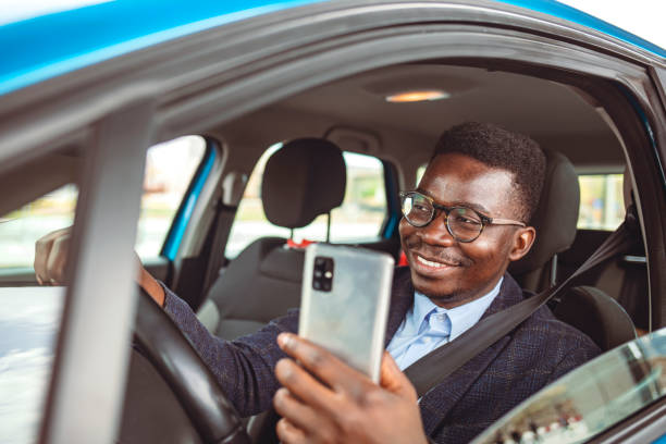 istock Businessman Dials a Message on the Smartphone in the Car. 1312915202
