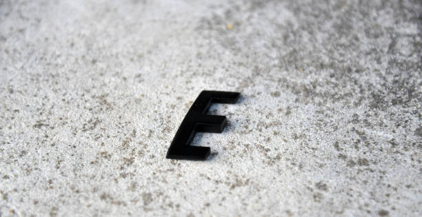 istock metal letter E on concrete background. 1312917054